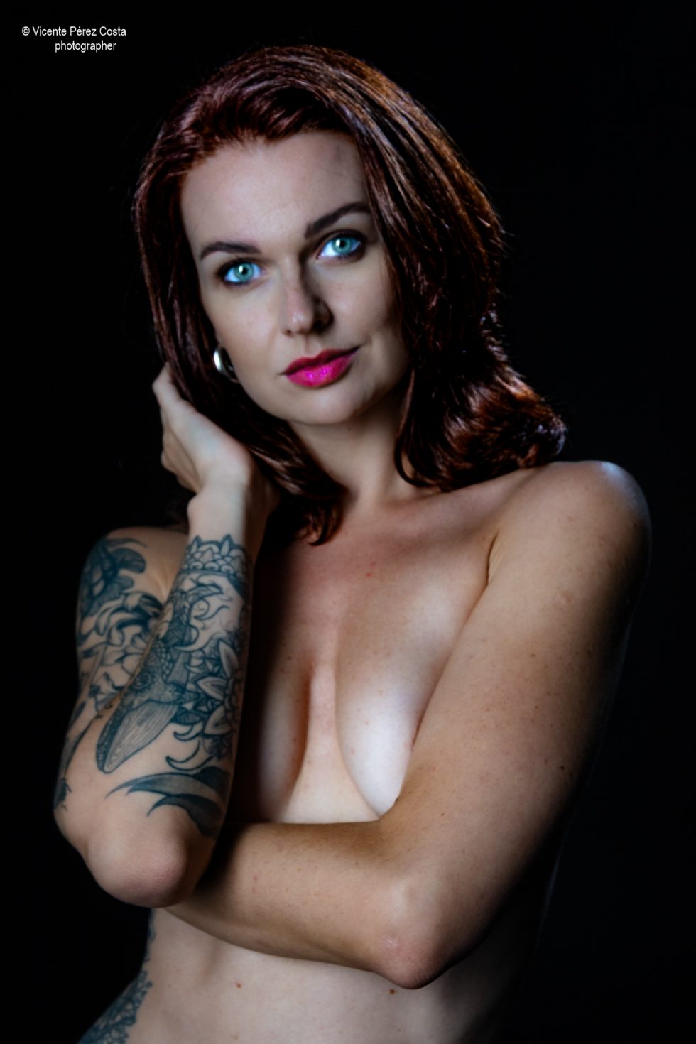 “Modelo posando en estudio con tela azul en una sesión de desnudo artístico, iluminada en clave suave y con estética minimalista.”