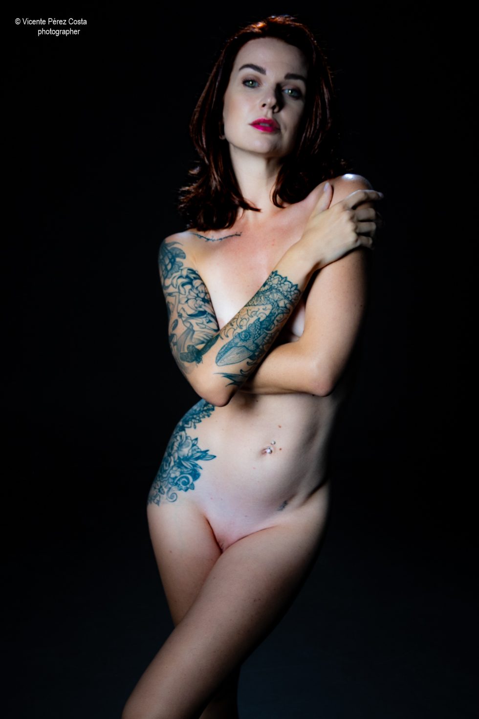 “Modelo posando en estudio con tela azul en una sesión de desnudo artístico, iluminada en clave suave y con estética minimalista.”