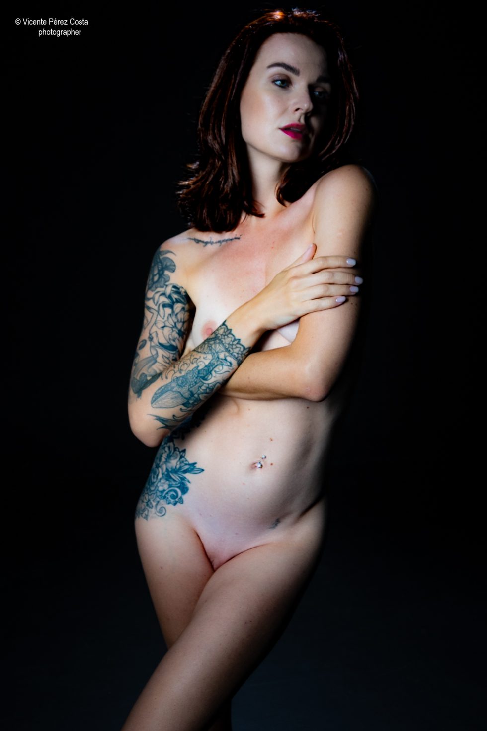 “Modelo posando en estudio con tela azul en una sesión de desnudo artístico, iluminada en clave suave y con estética minimalista.”