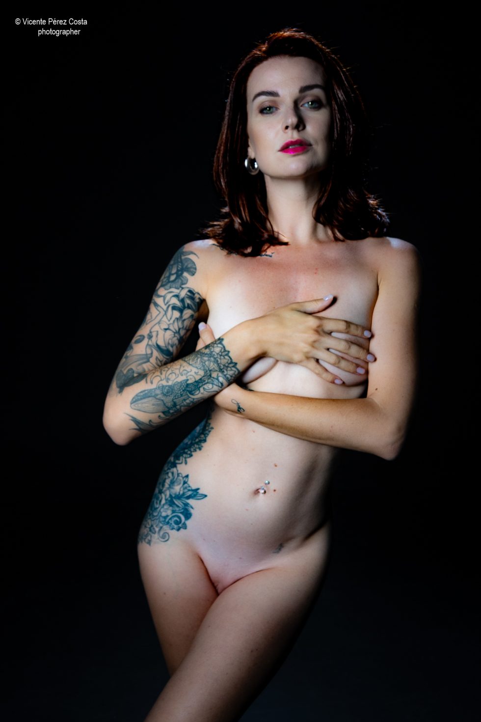 “Modelo posando en estudio con tela azul en una sesión de desnudo artístico, iluminada en clave suave y con estética minimalista.”